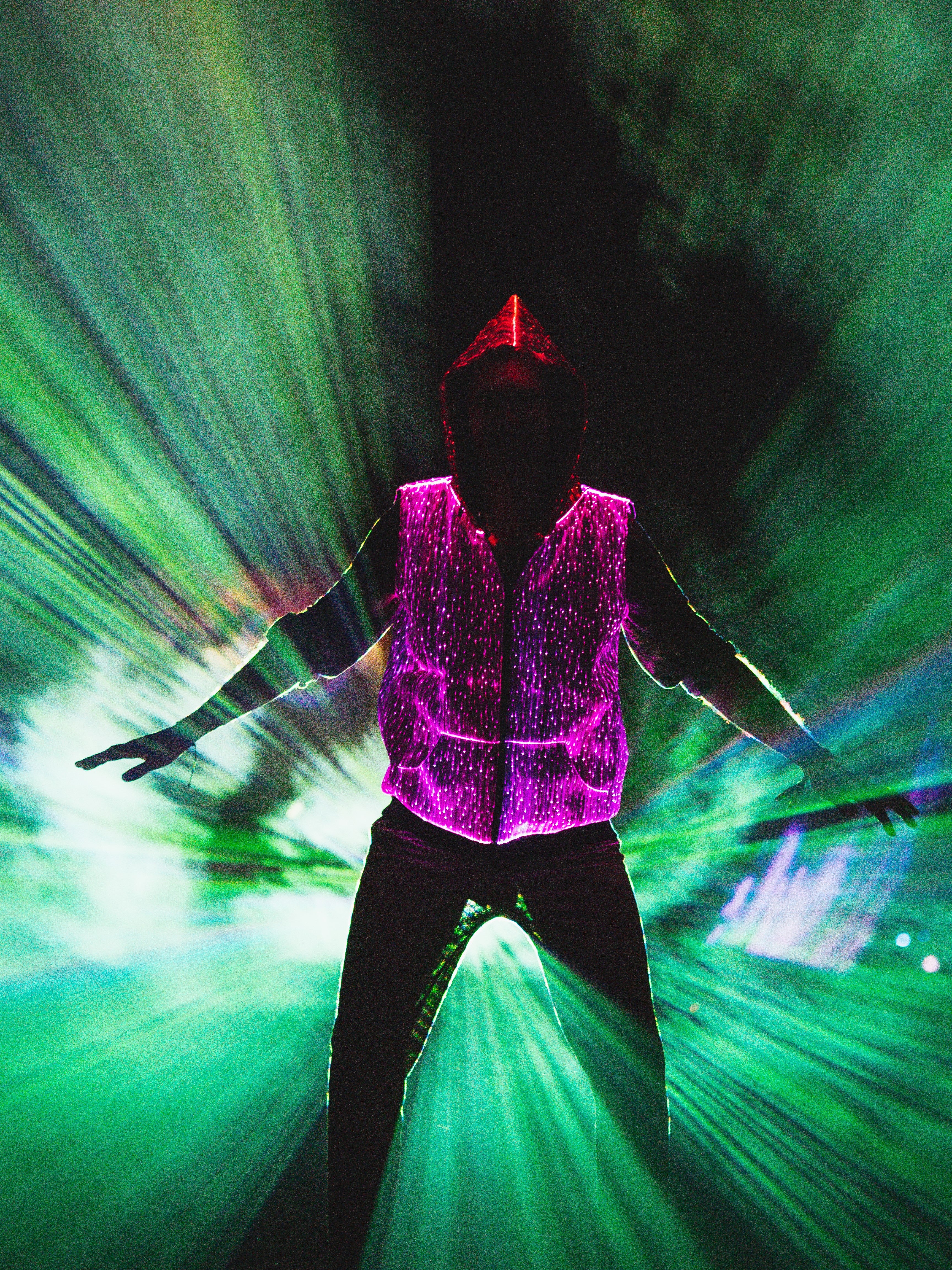 animated man wearing the NEBULITE vest on a festival, with lasers in the background