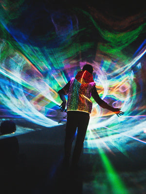 animated man wearing the NEBULITE vest on a festival, with lasers in the background